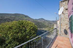 un balcone di una casa con montagne sullo sfondo di La Casa di Sandra a Noli a Noli