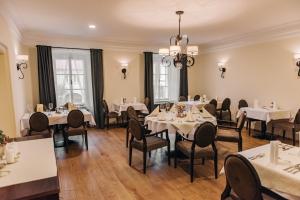 a dining room with white tables and chairs at Krone Penzion in Svätý Jur