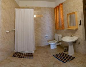 ein Bad mit einer Dusche, einem WC und einem Waschbecken in der Unterkunft Sunset Seaview Apartments in Marsalforn