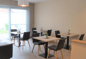 uma sala de jantar com mesas e cadeiras e uma janela em Gästehaus Gisch Sandra em Podersdorf am See