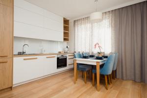 a kitchen with a dining table and blue chairs at ShortStayPoland Apartamenty in Warsaw
