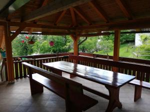 - un banc en bois sur une terrasse couverte avec une table dans l'établissement Apartmaji Pika, à Cerklje na Gorenjskem