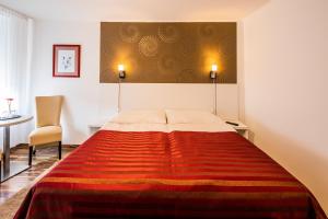 una camera con un letto con una coperta rossa di Riviéra Rooms Vendégszobák a Mosonmagyaróvár
