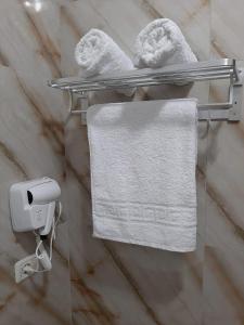 łazienka z białymi ręcznikami na ścianie w obiekcie Hotel Vila Arbri w mieście Berat