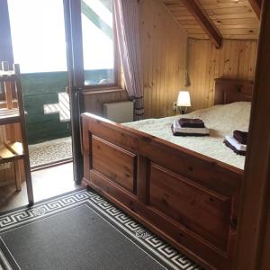 a bedroom with a large bed with a large window at Cottage Shchaslyvyi in Yaremche