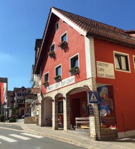 ein rotes Gebäude auf der Straßenseite in der Unterkunft Gasthof zum Löwen in Gößweinstein
