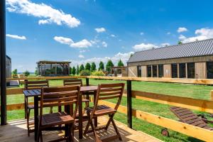 a wooden deck with a table and chairs and a building at Horse Glamping Park in Cirkovce