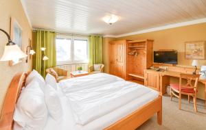1 dormitorio con 1 cama blanca grande y escritorio en Hotel Kellhof - Bed & Breakfast, en Gaienhofen