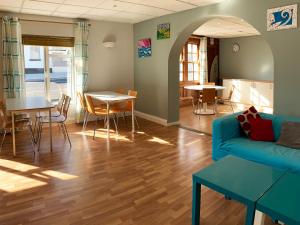 a living room with a blue couch and a table at Rougey Lodge Hostel in Bundoran