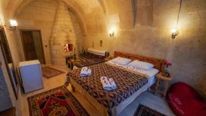 a bedroom with a bed with slippers on it at Asyada Suites Hotel in Nevsehir