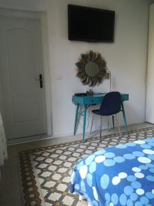 a bedroom with a table and a tv and a chair at Villa Corsini in Laigueglia