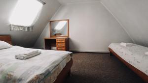 a attic bedroom with two beds and a mirror at Villa Tatiana on Lineinaya in Kaliningrad