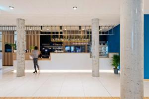 a woman standing at a bar in a building at Hotel Den Briel in Ghent