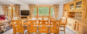 - une salle à manger avec une table et des chaises en bois dans l'établissement Les Pins - Apt 11 - BO Immobilier, à Châtel