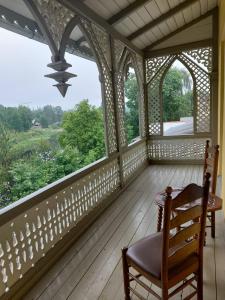 une terrasse couverte avec une chaise et une grande fenêtre dans l'établissement Hotel Viona, à Bauska