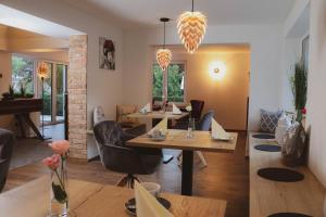 une salle à manger avec des tables, des chaises et un piano dans l'établissement Pension Heimat, à Ottenhöfen im Schwarzwald