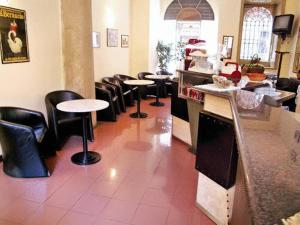 a restaurant with a row of tables and stools at Hotel Minerva in Milan