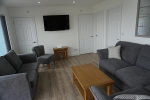 ein Wohnzimmer mit 2 Sofas und einem TV in der Unterkunft Deluxe Lundy View Villa With Sea Views in Westward Ho