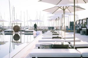 a row of tables with white umbrellas on a marina at Marina di Scarlino Resort in Puntone di Scarlino