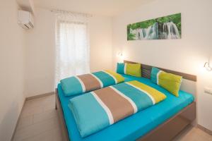 a bedroom with a blue couch with colorful pillows at Kiefer-Apartments in Rust