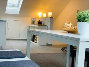 a white table in a kitchen with a plant on it at Ferienwohnung Munchen in Vaterstetten