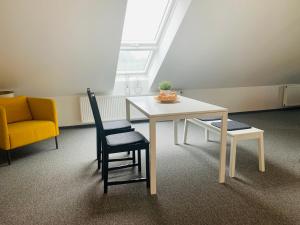 - une table et des chaises dans une chambre avec fenêtre dans l'établissement Ferienwohnung Munchen, à Vaterstetten