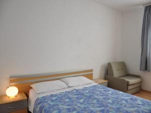 - une chambre avec un lit et une chaise dans l'établissement Pet friendly Apartments Licul, à Rabac
