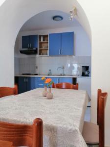 une cuisine avec une table et des armoires bleues dans l'établissement Pet friendly Apartments Licul, à Rabac