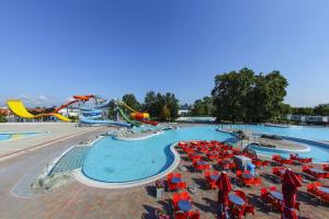 a swimming pool with red and blue chairs and a water park at Apartma Julija Hiška 59 in Čatež ob Savi