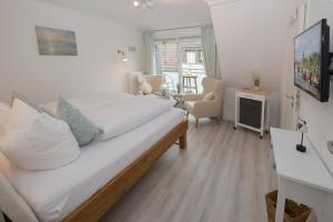 a bedroom with a bed and a living room at Hotel-Pension Achtern Diek in Büsum