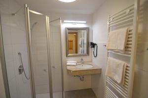 a bathroom with a shower and a sink and a mirror at Karlingerhof in Achenkirch