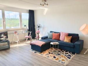 a living room with a blue couch and a table at großes Appartement mit Aussichtsbalkon in Ludwigsburg