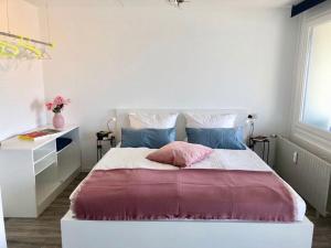 a bedroom with a large bed with a pink pillow at großes Appartement mit Aussichtsbalkon in Ludwigsburg