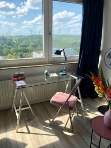 a desk with a lamp and a chair in front of a window at großes Appartement mit Aussichtsbalkon in Ludwigsburg