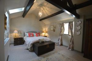 a bedroom with a bed and two lamps and a window at Haddon Grove Farm Cottages in Bakewell +140 photos