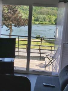 - un salon doté d'une fenêtre offrant une vue sur le lac dans l'établissement Balcons sur Seine - Vernon Giverny, à Vernon