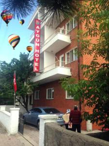 a man standing in front of a building with a sign at Aygun Hotel Avanos in Avanos