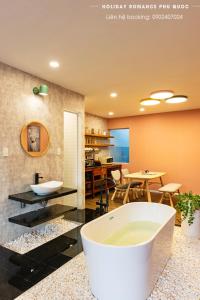 ein Badezimmer mit einer Badewanne und ein Esszimmer mit einem Tisch in der Unterkunft Minimalist & Modern Apartment III in Phu Quoc
