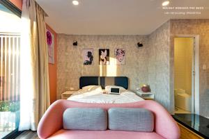 ein Schlafzimmer mit einem Bett mit einer rosa Bank in der Unterkunft Minimalist & Modern Apartment III in Phu Quoc