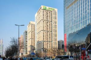 沈阳沈阳金廊智选假日酒店  的城市中心的一座高大的白色建筑