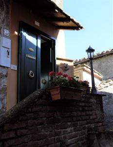 una puerta azul en un edificio con una maceta en Sui tetti del borgo en Capranica