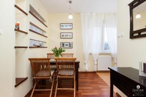 d'une salle à manger avec une table, des chaises et une fenêtre. dans l'établissement Jantar Apartamenty- Zielone Tarasy, à Kołobrzeg