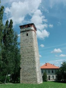 an old brick tower in front of a building at Sobe Lara in Gradačac