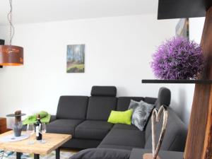 uma sala de estar com um sofá preto e uma mesa em Chalet Am Scheidt em Medebach