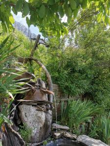 a garden with a rock and a water fountain at Chambre d'hôtes couvent d'Alando in Alando