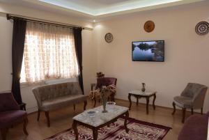 a living room with chairs and a table and a tv at Aygun Hotel Avanos in Avanos
