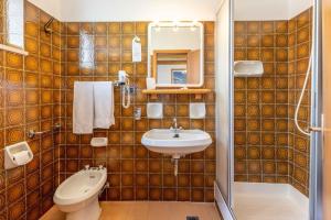 安達洛的住宿－Hotel Ghezzi，一间带水槽、卫生间和镜子的浴室