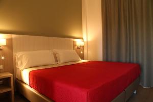a bedroom with a bed with a red blanket at Pausania Inn in Tempio Pausania
