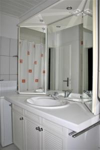 bagno con lavandino bianco e grande specchio di Herrenhof a Worms