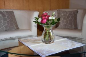 a vase of flowers sitting on a glass table at Pension Wiesner in Hameln